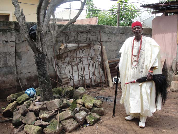 Obi Esonanjo Awolo beside his brothers' grave.