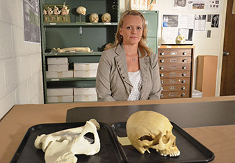 Erin Kimmerle seated at a table with human bones.