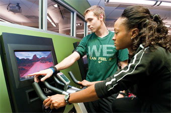 Nakreshia Causey rides an exercise bike with a screen showing a first-person ride in the country.