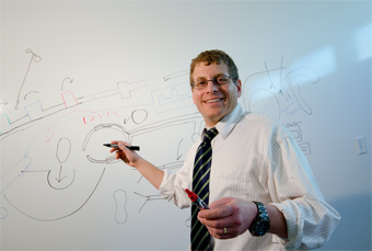 Dr. Stuart Hart standing in front of a whiteboard.