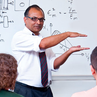 USF professor Autar Kaw teaches in front of a whiteboard.