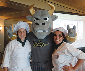 Two hospitality students pose with Rocky.