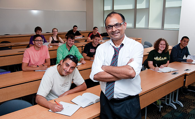 Professor Autar Kaw stands in front of students at desks in a classroom,