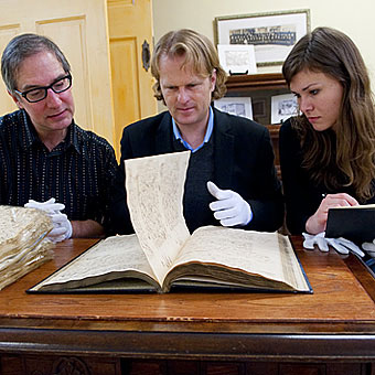 Arthur Tarratus, J. Michael Francis and Saber Gray examine a document.
