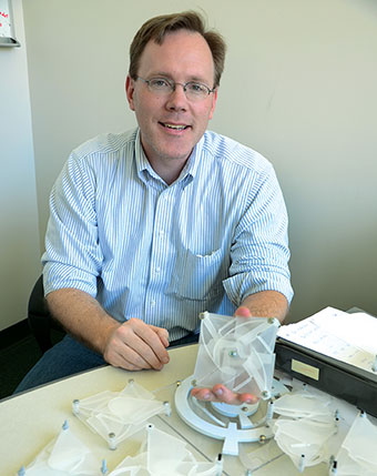 Professor Craig Lusk holding one of his polymer shapes.