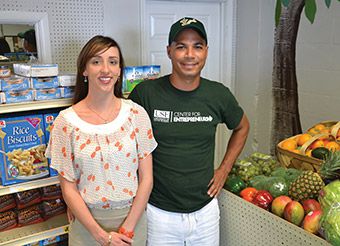 Andrea Little and Hector Angus standing next to produce and other packaged goods.