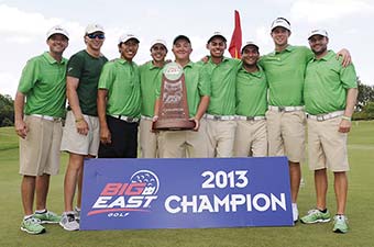 The USF men's golf team stands on grass holding a large trophy with a large sign at their feet that reads Big East Golf 2013 Champion.